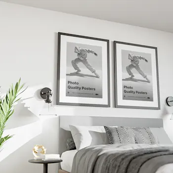 Two framed photo quality posters displayed above a modern bed in a stylish bedroom, featuring black and white images of a dancer in motion with the text