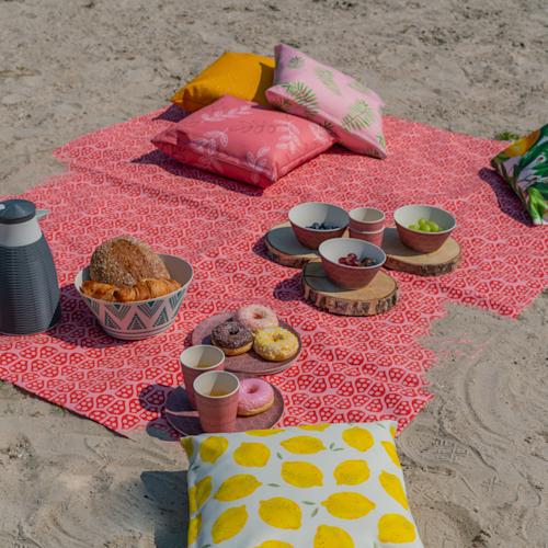 Image of a cheap picnic blanket on the beach. Print with your own design!