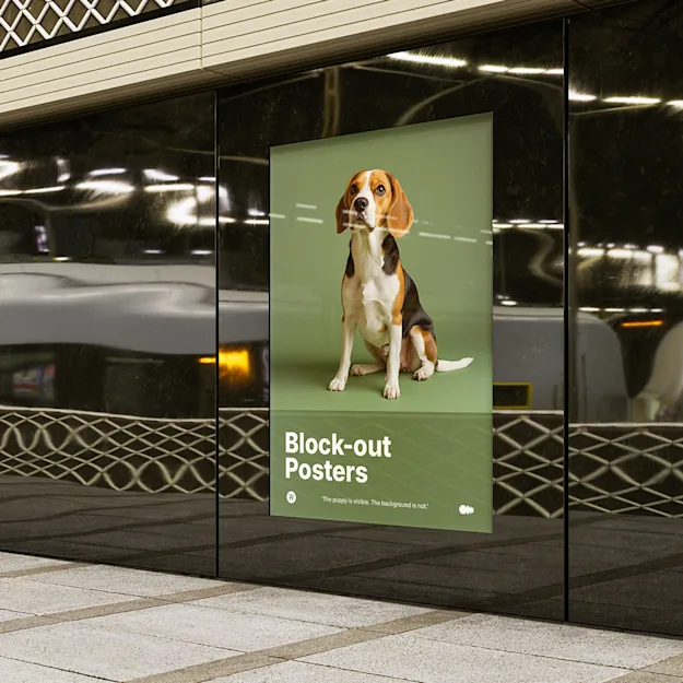 Block-out poster displayed on a black wall at a train station, featuring a beagle dog on a green background with the text