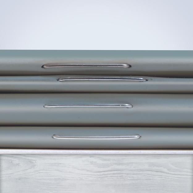 A stack of four grey stapled booklets on a wooden table showcasing the staple binding.