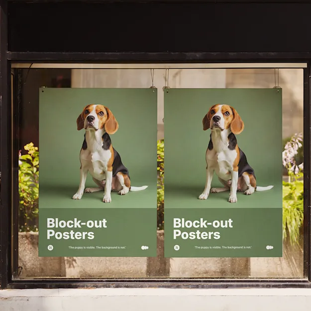 Two block-out posters displayed in a storefront window, featuring a beagle dog on a green background with the text 